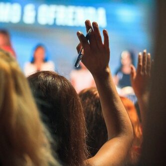 Students raising their hands at a lecture.