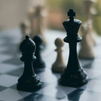 Black runner and king on a chess board.
