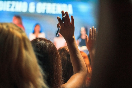 Students raising their hands at a lecture.